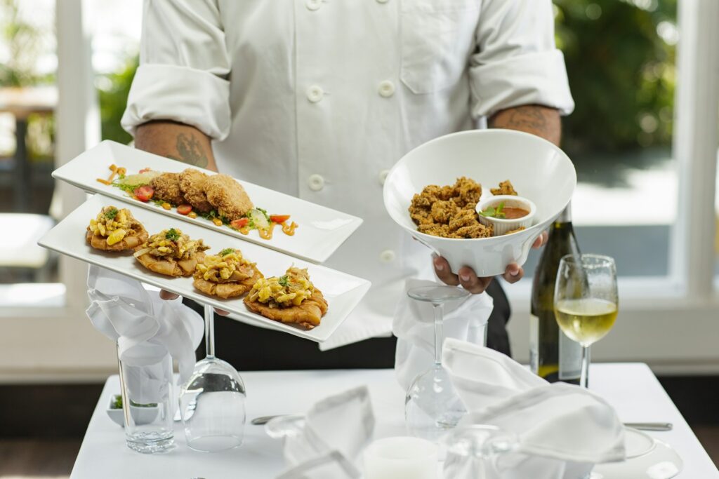 person in white dress shirt holding white ceramic bowl with food