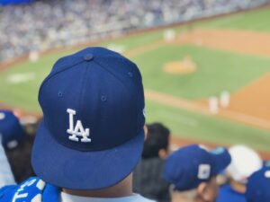 selective focus photography of person wearing LA Dodgers cap looking at baseball field